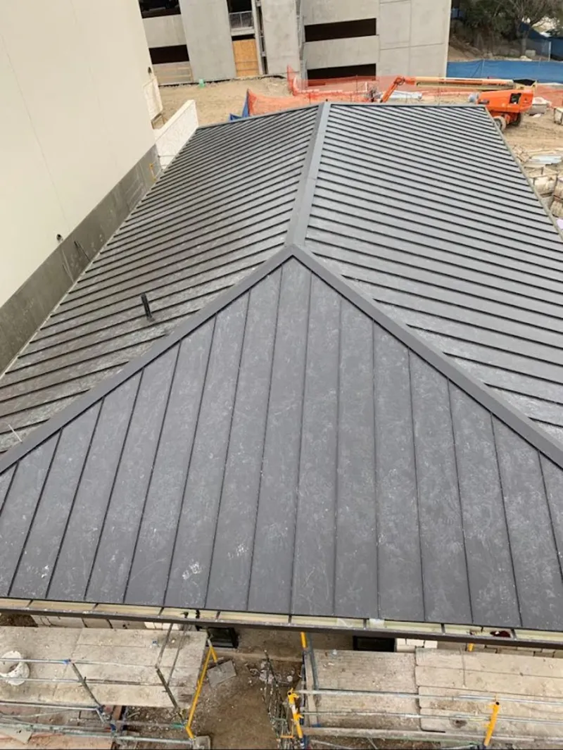 Commercial metal roof construction with crane equipment in Coppell